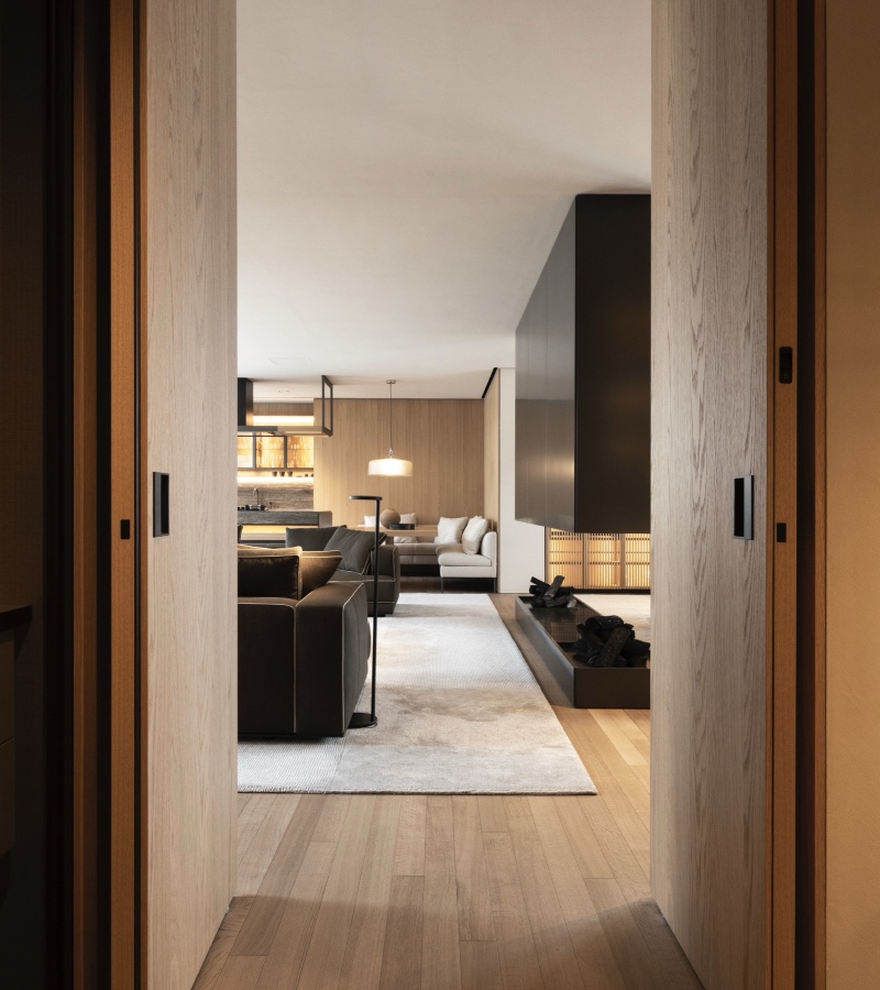 The serene foyer features the Mateo table and Porta Volta chairs, opening into a refined living space that includes the Prime kitchen and Turner sofa. / Photo Molteni