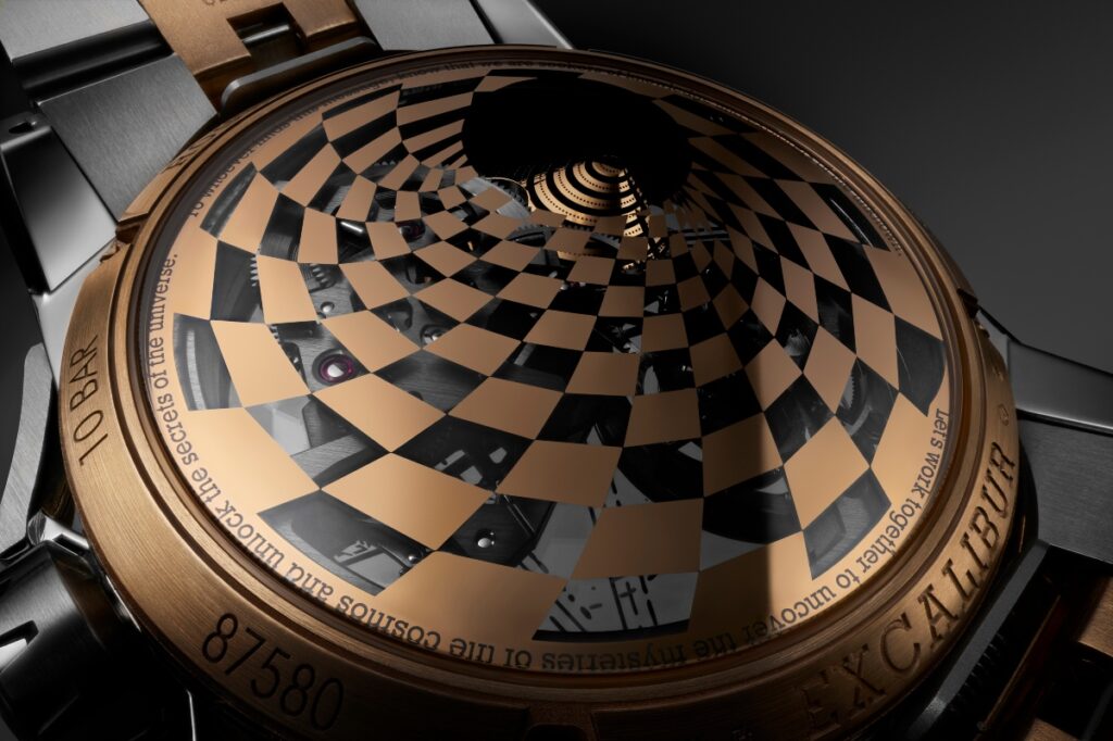 At 1 o’clock, a rotating disc reveals a miniature galaxy in motion. Planets, rings, and nebulae in rose gold orbit over a matte black backdrop. / Photo Dr. Woo