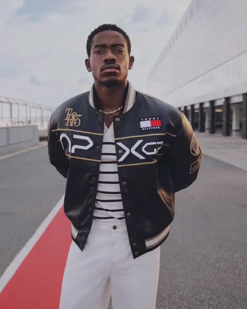 The capsule distills racing iconography into everyday wear. Moto-inspired graphics reimagine the mechanic shirt; a vegan leather varsity jacket brings a touch of retro muscle / Photo via Tommy Hilfiger
