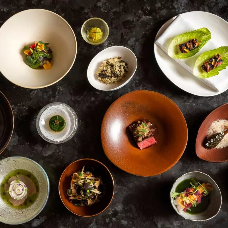 The minimalist yet sophisticated ambiance of Atomix enhances the sensory experience, making every meal a memorable event. / Photo via Michelin Guide