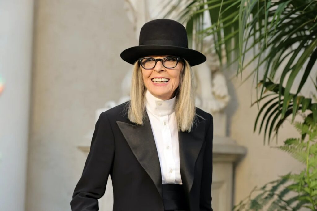 Her aesthetic drew from menswear, vintage tailoring, and a hint of bohemian rebellion. The broad-brimmed hats, tailored jackets, ties, and high-waisted trousers challenged traditional femininity. / Photo Yahoo