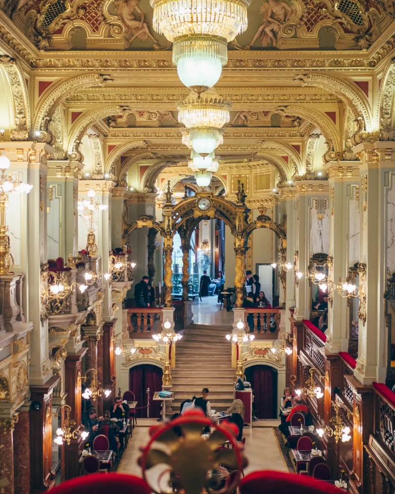 Designed in the Italian Renaissance style, the interior is a dazzling spectacle of soaring marble columns, glistening chandeliers / Photo via New York Café Budapest
