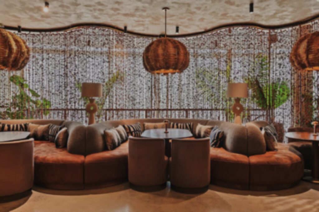 The architecture of MILA Miami is a study in contrasts—earthy textures against polished surfaces, organic forms softened by warm light, and a rooftop setting that feels suspended between sky and sea. . / Photo via MILA